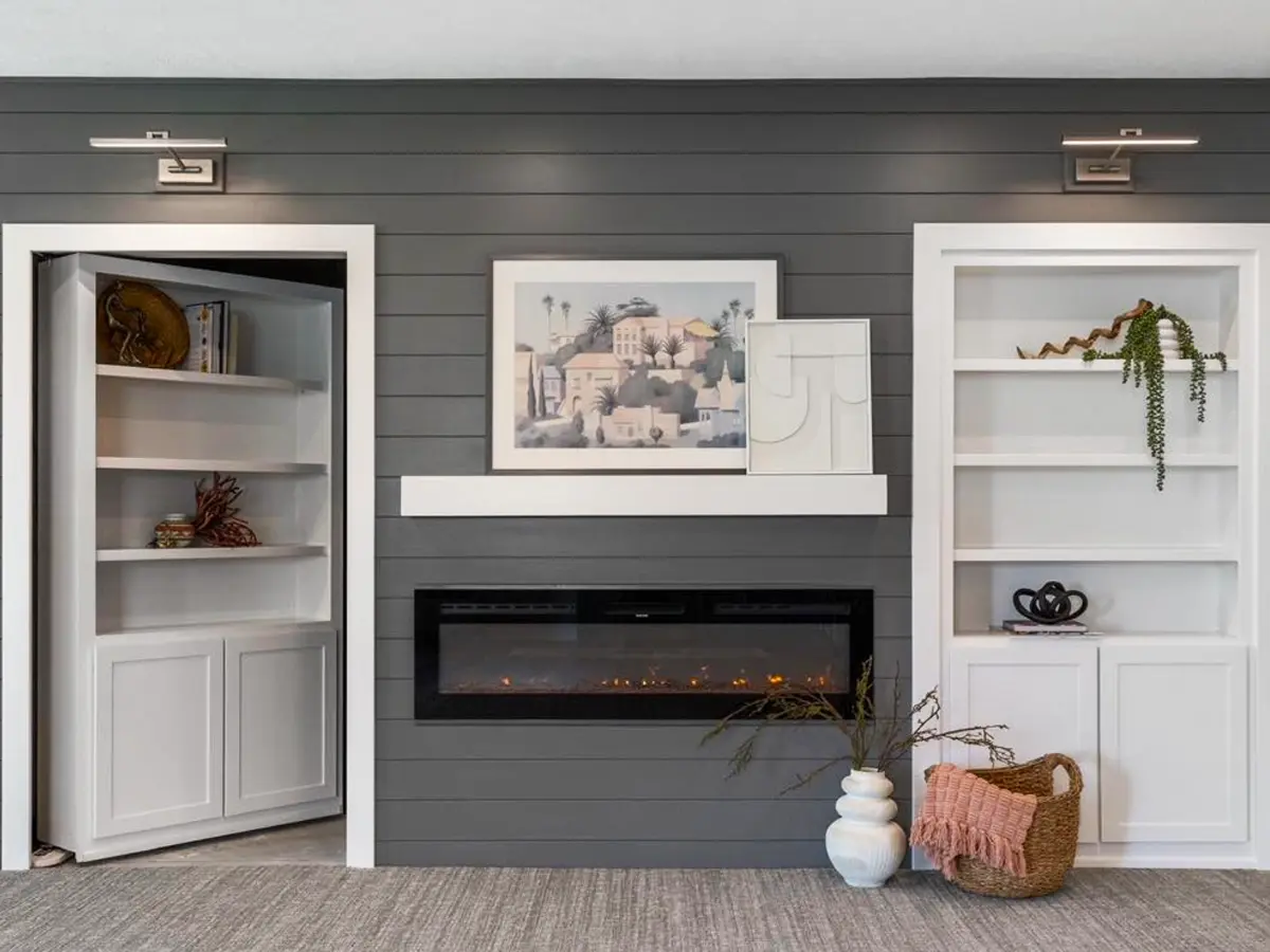 Cozy living room with a built-in fireplace, white shelving, and farmhouse-style decor.